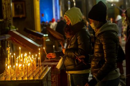 Санкт-Петербург. Девушки ставят поминальные свечи на канун в Казанском кафедральном соборе во время Пасхального богослужения.