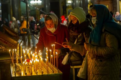 Санкт-Петербург. Прихожанки ставят поминальные свечи на канун в Казанском кафедральном соборе во время Пасхального богослужения.