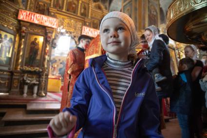 Пермь.  Девочка во время пасхальной службы в храме.