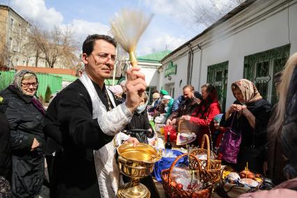 Красноярск. Прихожане и священнослужитель во время освящения пасхальных куличей и яиц у Покровского кафедрального собора.