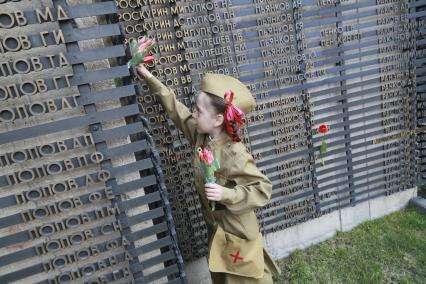Барнаул. День Победы. Девочка в военной форме возлагает цветы к Мемориалу Славы.