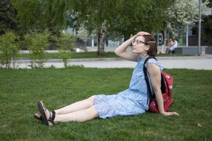 Пермь. Девушка сидит на газоне.