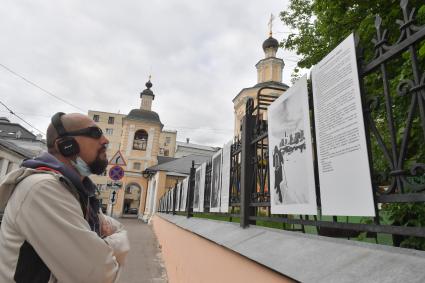 Москва.  Фотографий  на выставке под открытым небом -  проект `Люди` журналиста и фотографа Юрия Роста , у храма Живоначальной Троицы в Хохлах .