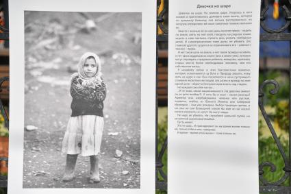 Москва. Фотографий на выставке под открытым небом - проект `Люди` журналиста и фотографа Юрия Роста , у храма Живоначальной Троицы в Хохлах .