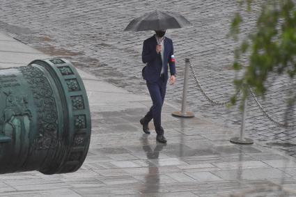 Москва.  Мужчина под зонтом во время дождя.