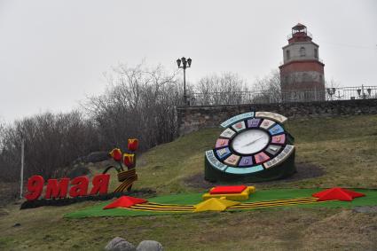 Мурманск. Декоративные часы на клумбе.