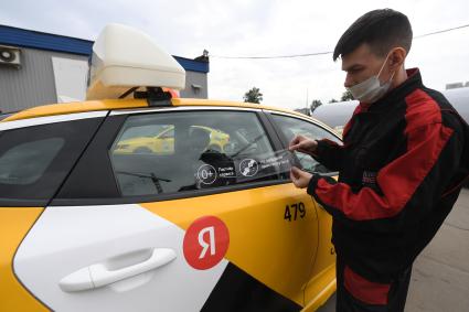 Москва. Наклейка с надписью `Не забудь пристегнуться` на стекле автомобиля такси `Яндекс Go`.