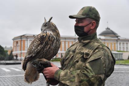 Москва. Сотрудник орнитологической службы с филином Филей на территории Московского Кремля.