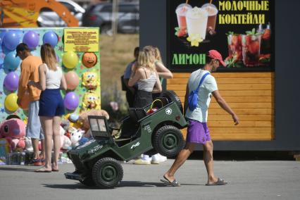 Екатеринбург.Мужчина тащит электромашинки в зоне уличных аттракционов у ЦПКиО им.Маяковского