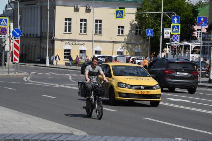 Москва. Сотрудник службы доставки еды на велосипеде.