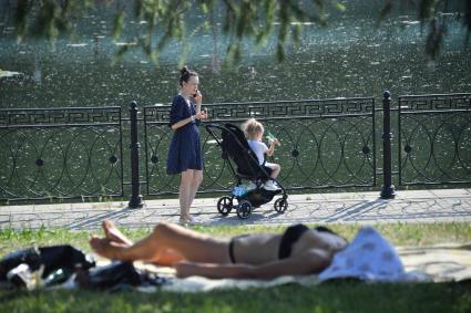 Москва. Девушка с ребенком в коляске гуляет по набережной.