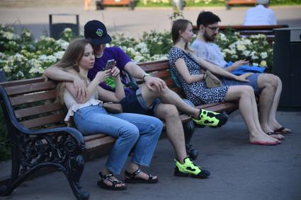 Москва. Молодые люди на скамейке в паркеГорького.