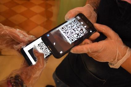 Москва. Сотрудница пиццерии Pronto pizza проверяет QR-код у посетительницы на входе в заведение.