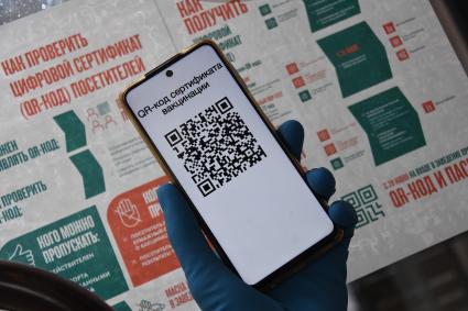 Москва. Сотрудница кафе проверяет QR-код у посетителей на входе в заведение.