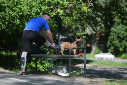 Екатеринбург. Мужчина в парке делает зарядку, во время прогулки с собакой