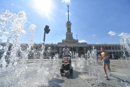 Москва. Мужчина с детьми на территории сухого фонтана у здания Северного речного вокзала.