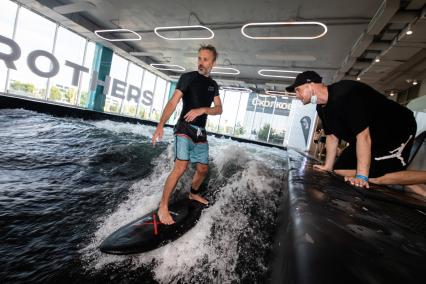 Москва. Молодой человек во время тренировки по серфингу в серфинг-центре `Surf Brothers Сколково` на территории бизнес-центра `Амальтея`.