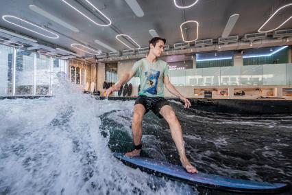 Москва. Молодой человек во время тренировки по серфингу в серфинг-центре `Surf Brothers Сколково` на территории бизнес-центра `Амальтея`.