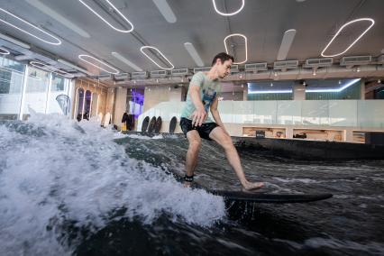 Москва. Молодой человек во время тренировки по серфингу в серфинг-центре `Surf Brothers Сколково` на территории бизнес-центра `Амальтея`.