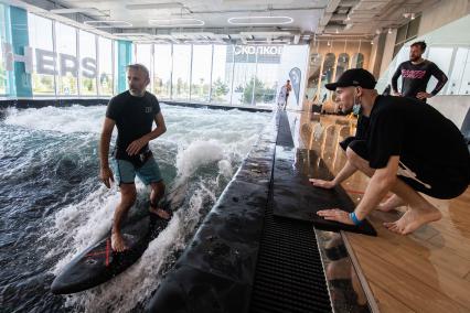 Москва. Молодой человек во время тренировки по серфингу в серфинг-центре `Surf Brothers Сколково` на территории бизнес-центра `Амальтея`.