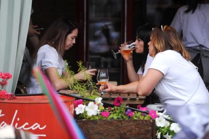 Санкт-Петербург. Женщины пьют пиво на веранде кафе.