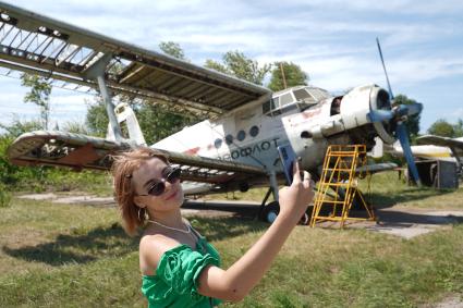 Самарская область. Девушка делает селфи на фоне самолета Ан-2ТП на учебном аэродроме Самарского университета.