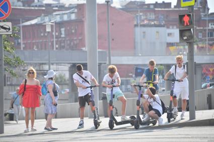 Москва. Дети с самокатами переходят улицу.