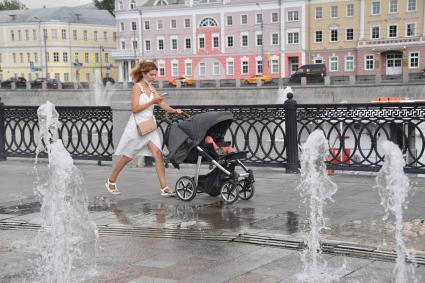 Москва. Женщина с коляской гуляет на набережной.