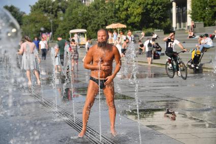 Москва. Мужчина в плавках у фонтана в парке Музеон.