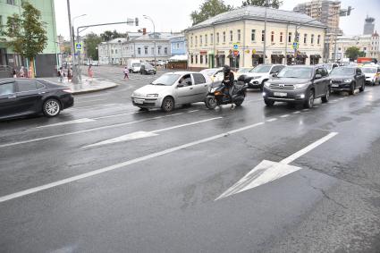 Москва. Мотоциклист и машины едут по дороге.