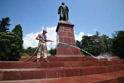 Ялта. Последствия наводнения, произошедшего 18 июня. Мужчина моет из шланга памятник Ленину.