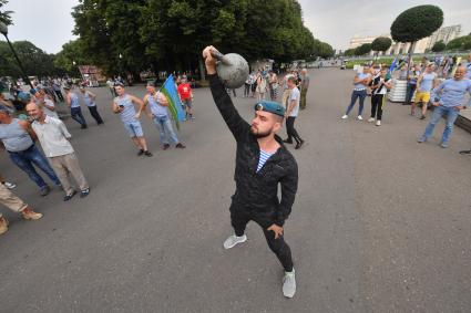 Москва. Десантник поднимает гирю во время празднования Дня Воздушно-десантных войск России на ВДНХ.