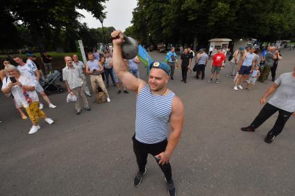 Москва. Десантник поднимает гирю во время празднования Дня Воздушно-десантных войск России на ВДНХ.