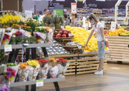 Пермь. Девушка выбирает фрукты в супермаркете.