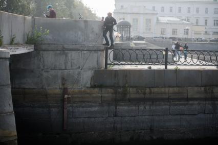 Екатеринбург. Подросток бросает магнит в городской пруд, для вылова металлических предмтов, в том числе денег