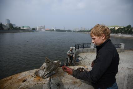 Екатеринбург. Подросток Александр показываетденьги, выловленные из городского пруда, с помощью мощного магнита