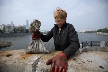 Екатеринбург. Подросток Александр показывает мешок с монетами, выловленный из городского пруда, с помощью мощного магнита