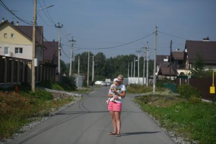 Екатеринбург. Женщина с ребенком на дороге в отдаленном жилом районе города