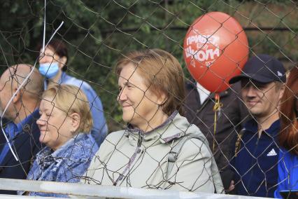 Барнаул. Родители наблюдают за праздничной линейкой в школе в День знаний.