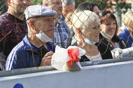 Барнаул. Родители наблюдают за праздничной линейкой в школе в День знаний.