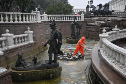 Москва.  Сотрудник коммунальных служб моет фонтан `Иван царевич и царевна лягушка`на манежной площади.