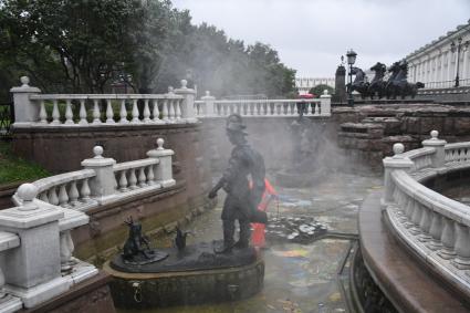 Москва.  Сотрудник коммунальных служб моет фонтан `Иван царевич и царевна лягушка`на манежной площади.