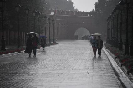 Москва. Прохожие под дождем в Александровском саду.