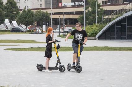 Пермь. Молодые люди катаются на электросамокатах.