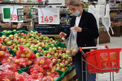 Москва. Покупатели у витрины с яблоками в  торговом зале магазина.