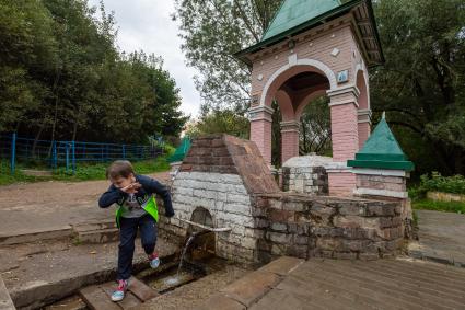 Москва. Мальчик пьет воду из источника на экологической тропе `У истоков рек`на территории ландшафтного заказника Теплый Стан.