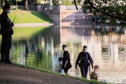 Москва. Полицейские беседуют с отдыхающими на Патриарших прудах.