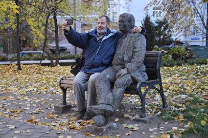 Москва.  Мужчина сидит рядом со скульптурой мужчины на скамейке во дворе  дома 13  на Садово-Черногрязской улице.