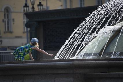 Москва. Девочка тянется к фонтану.