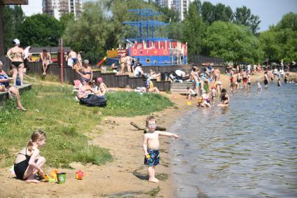 Москва. Пляж в Строгино. Мальчик показывает пальцем на воду.